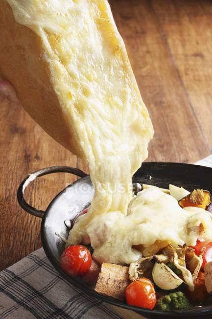 Raclette with vegetables on pan — Stock Photo