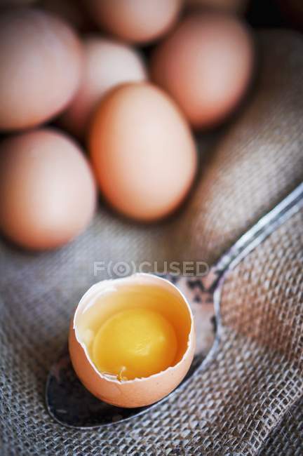 Huevo agrietado en cuchara - foto de stock