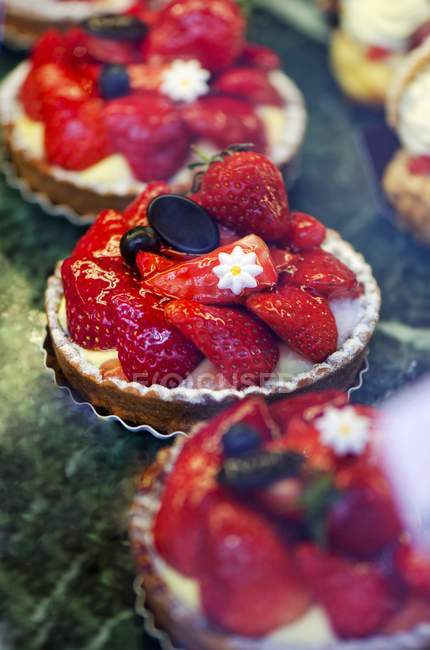 Strawberry tartlets on showcase — Stock Photo