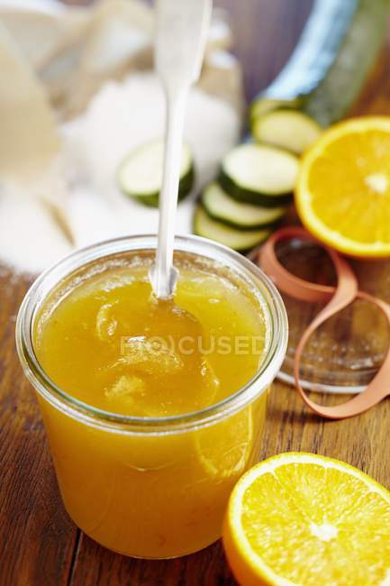 Courgette and orange marmalade over wooden surface — Stock Photo