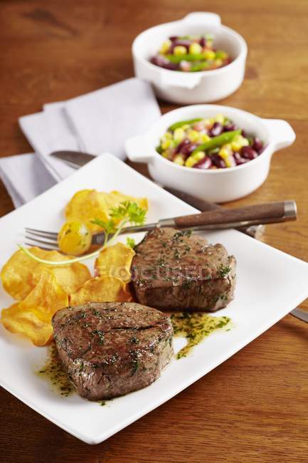 Steak with a bean salad and potato crisps — Stock Photo