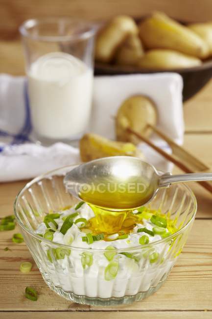 Pommes de terre neuves avec quark d'oignon en pot de verre sur surface en bois — Photo de stock