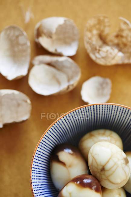 Closeup top view of hard-boiled shelled eggs stained with tea and shells — Stock Photo