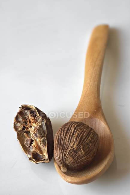 Cardamome noire sur cuillère en bois — Photo de stock