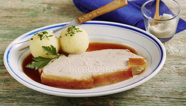 Крупным планом жареной свинины с треском и картофельными пельменями — стоковое фото