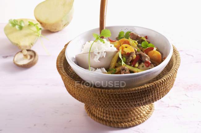 Stir-fried duck with vegetables on white plate over straw stand — Stock Photo