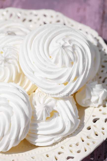 Meringues on plate and on table — Stock Photo