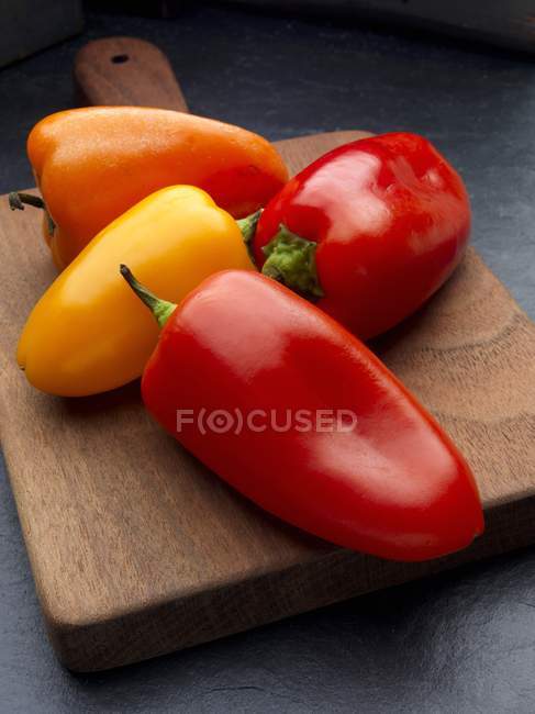 Vermelho com pimentas amarelas e laranja — Fotografia de Stock