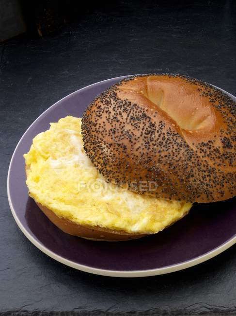 Closeup view of scrambled egg on a poppy seed roll — Stock Photo