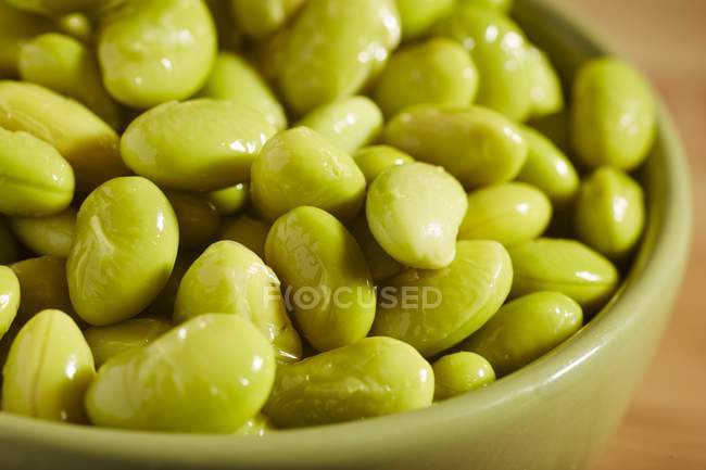 Boiled edamame beans - unripe soya beans in green bowl — Stock Photo