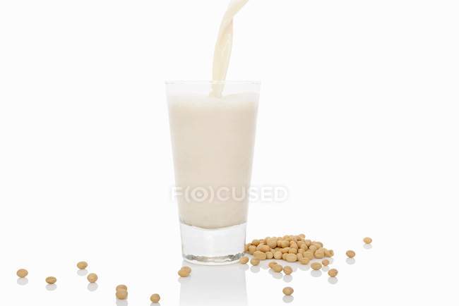 Latte di soia versato nel vetro — Foto stock
