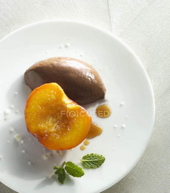 Карамельные персики с шоколадным мороженым — стоковое фото