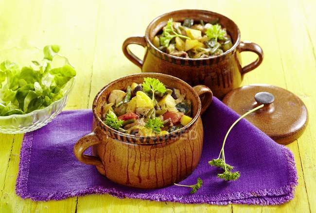 Djuwetsch Bulgarian vegetable stew in brown pots over towel — Stock Photo