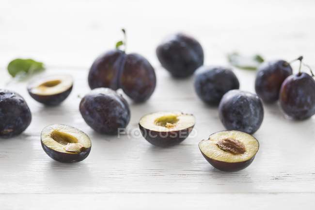 Whole and halved Fresh damsons — Stock Photo