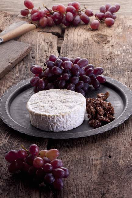 Brie with grapes and caramelised nuts — Stock Photo