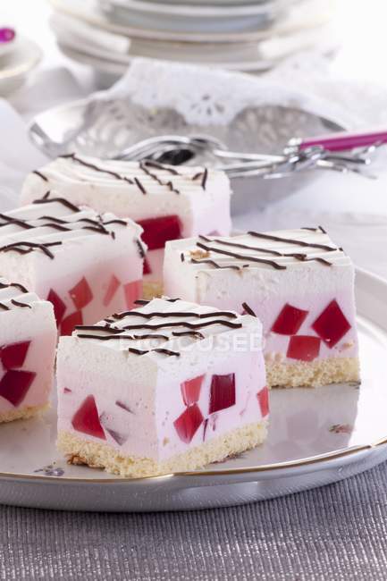 Tranches de crème avec des cubes de gelée rouge — Photo de stock
