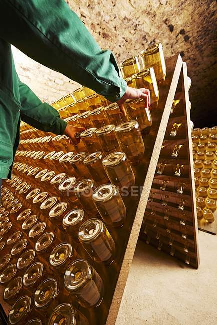 Worker moving bottles of champagne — Stock Photo