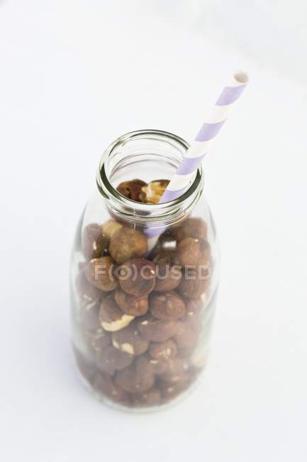 Hazelnuts in milk bottle — Stock Photo
