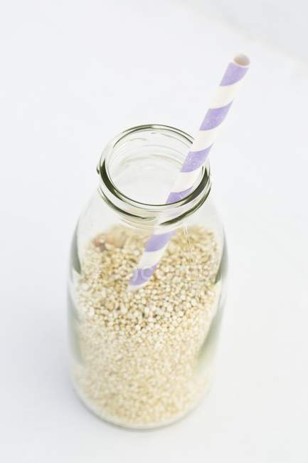 Quinoa em uma garrafa de leite — Fotografia de Stock