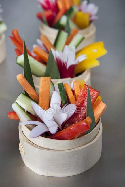 Bâtonnets de légumes avec des fleurs de radis sur la surface grise — Photo de stock