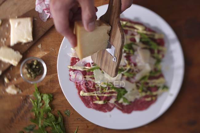 Parmesan being grated by hands — Stock Photo