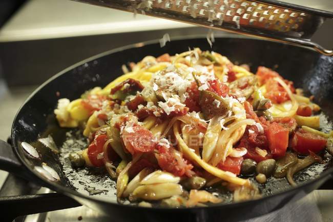 Parmesan wird auf Nudeln gerieben — Stockfoto