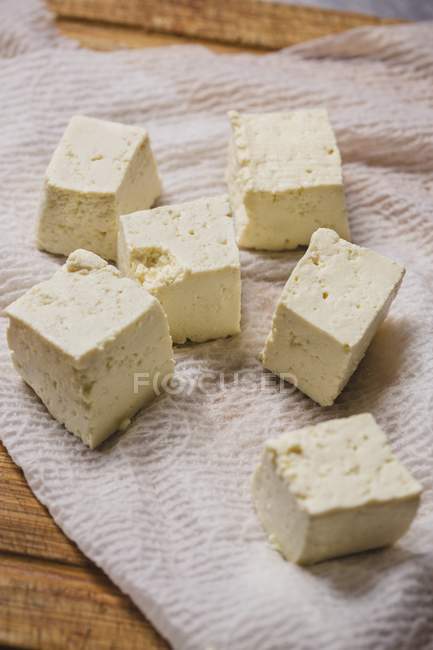 Vista de cerca del queso de tofu en cubitos en un paño - foto de stock