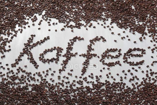 Слово Кава, написана з кавовими зернами — стокове фото