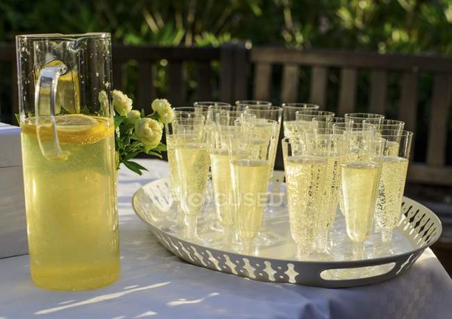 Closeup view of lemonade and flowers on garden table — Stock Photo