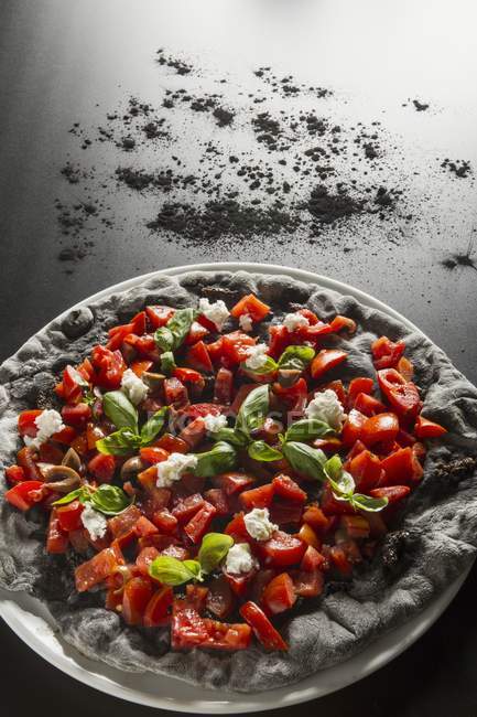 Pizza negra con pimientos - foto de stock