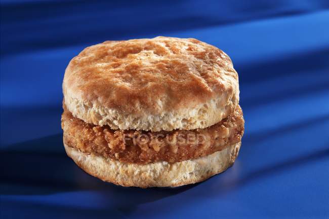 Slice of breaded sausage on blue — Stock Photo