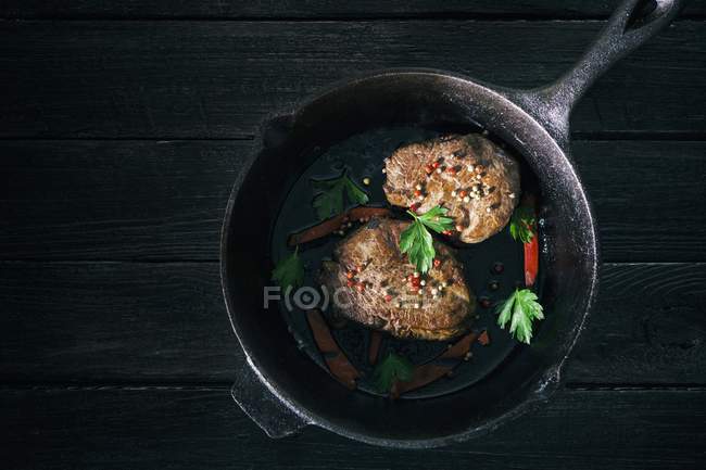 Pepper steaks in black cast-iron pan — Stock Photo