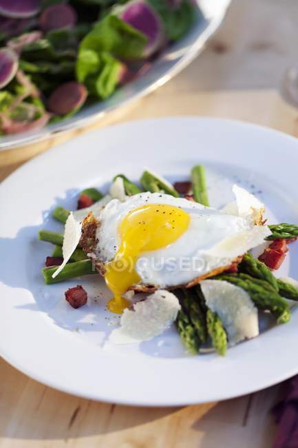 Fried egg on green asparagus — Stock Photo