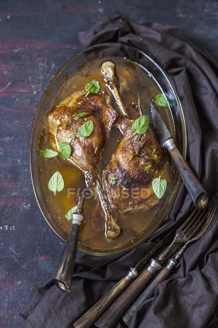 Top view of goose legs in a beer broth with old cutlery — Stock Photo