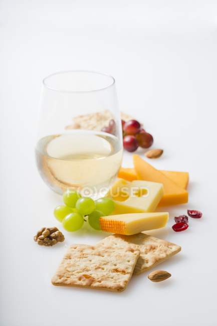 Крекеры и вино на белом — стоковое фото