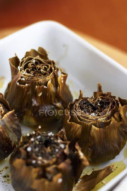 Oven-baked artichokes in white dish — Stock Photo