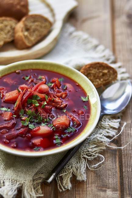 Borscht - Rote-Bete-Suppe auf Teller über Handtuch auf Holzoberfläche — Stockfoto