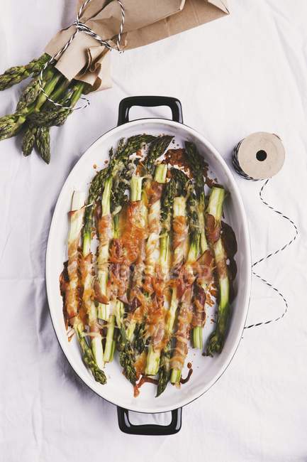 Gratinated green asparagus with ham — Stock Photo