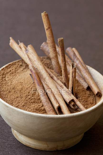 Ground cinnamon and cinnamon sticks — Stock Photo