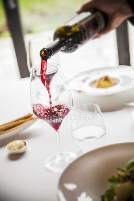 Vin rouge versé dans un verre — Photo de stock