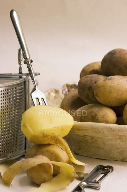 Частично очищенный картофель на вилке — стоковое фото