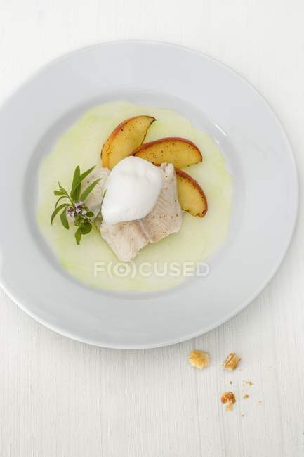 Steamed fish flipped on a kohlrabi carpaccio with lemon foam and roasted apple wedges — Stock Photo