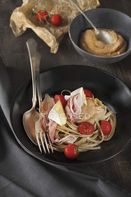 Tagliatelle pasta with prosciutto and Camembert — Stock Photo