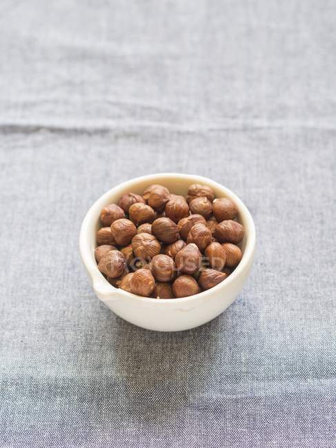 Hazelnuts in ceramic mortar — Stock Photo