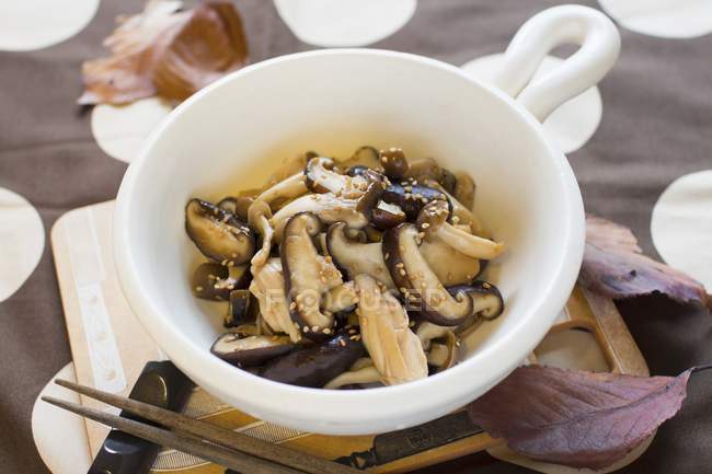 Mushroom umatsukuda-ni Simmered dish in soy sauce and sugar on white plate over wooden desk — Stock Photo