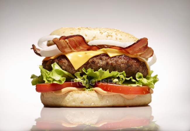 Bacon cheeseburger with vegetables — Stock Photo