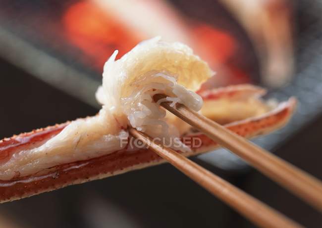 Closeup view of broiled crab on chopsticks — Stock Photo