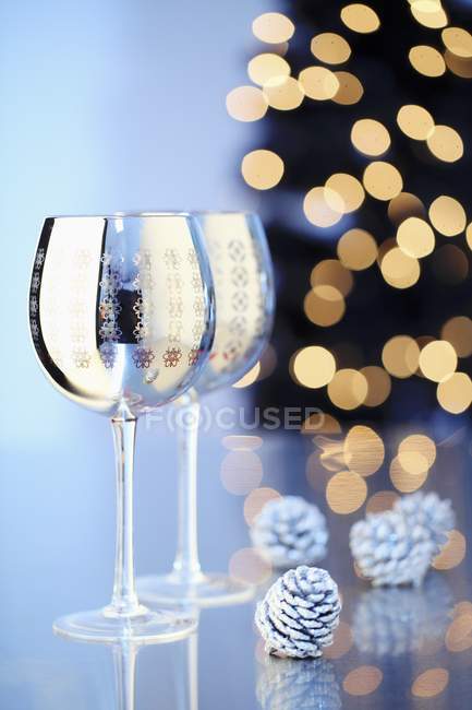 Vista de cerca de dos copas de vino plateadas impresas con motivos navideños - foto de stock