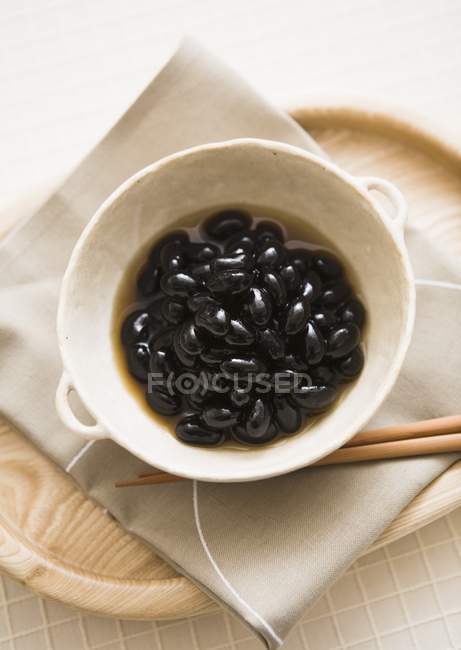 Composta di fagioli neri su piatto bianco — Foto stock