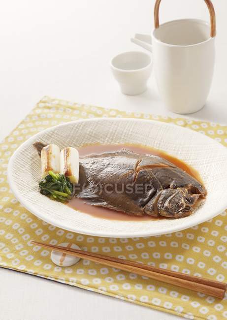 Vue rapprochée de poissons de plie mijotés dans de la sauce soja — Photo de stock